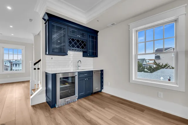 a kitchen with granite countertop white cabinets and wooden floors