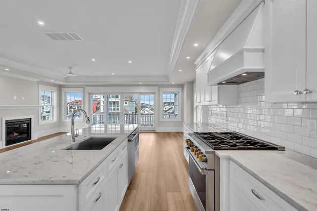 a view of an empty room with wooden floor fireplace and a window