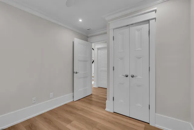 a view of a hallway with a wooden floor and entryway