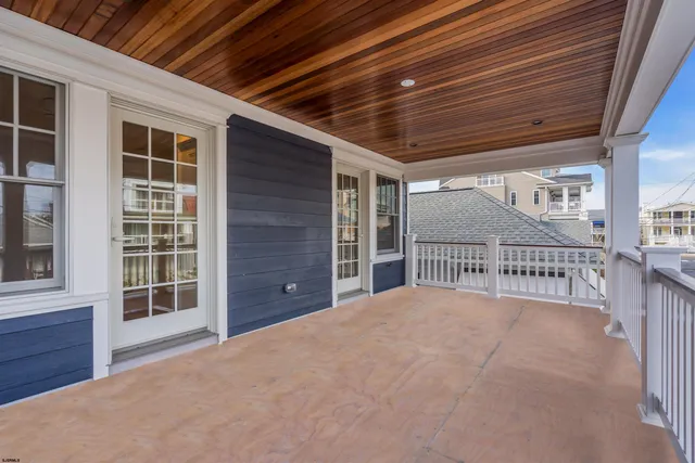 an empty room with wooden floor fireplace and windows