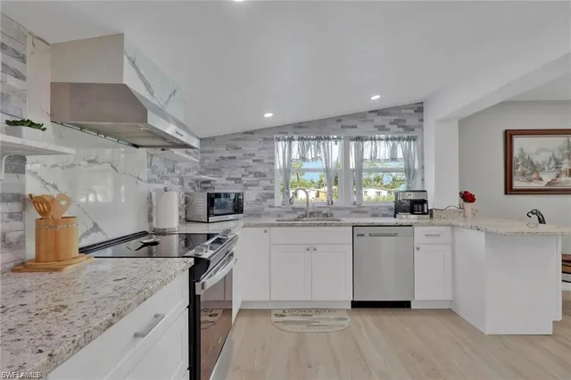 a kitchen with stainless steel appliances granite countertop a sink stove cabinets and wooden floor