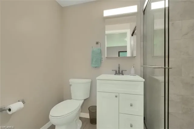 a bathroom with a granite countertop toilet a sink and a mirror