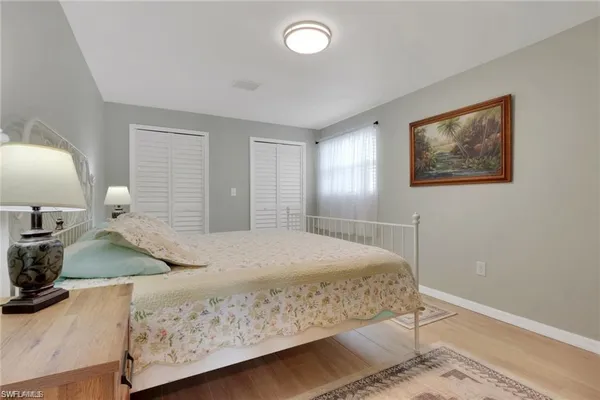 a bedroom with a bed and lamp on dresser