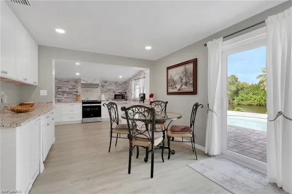 a view of a dining room with furniture and a kitchen