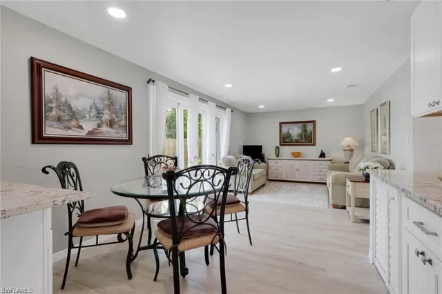 a living room with furniture and a dining table with wooden floor