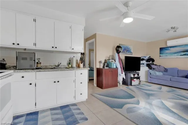a living room with furniture a flat screen tv and kitchen view