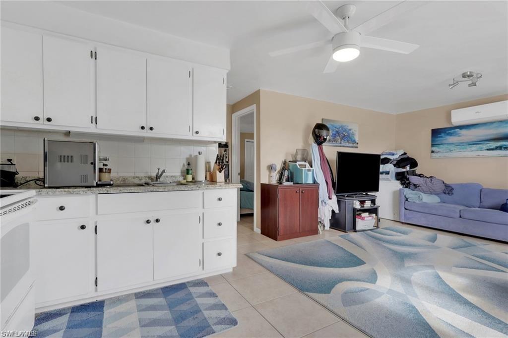 829 107th Avenue North Naples, FL 34108 - Photo 31 of 34 a living room with furniture a flat screen tv and kitchen view