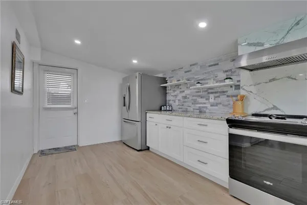 a kitchen with granite countertop white cabinets and white appliances