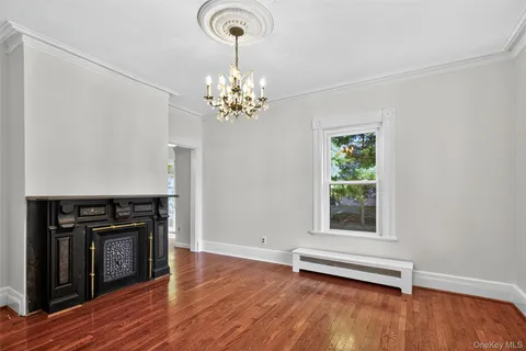 a view of an empty room with a fireplace and a window