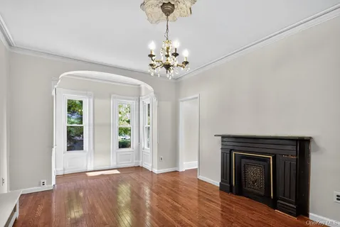a view of a hallway with wooden floor and a kitchen