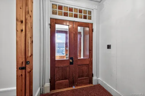 an empty room with wooden floor a chandelier and windows