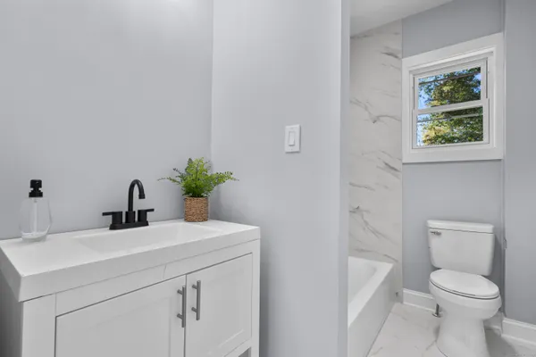 a bathroom with a sink toilet and a mirror