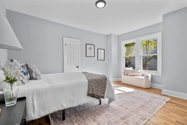 a spacious bedroom with a bed and wooden floor
