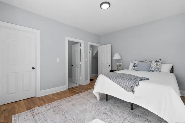 a spacious bedroom with a bed and wooden floor