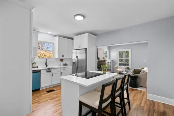 a kitchen with a dining table chairs refrigerator and stove