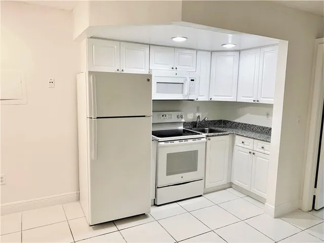 a white refrigerator freezer sitting inside of a kitchen