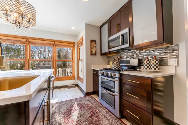a kitchen with stainless steel appliances granite countertop a stove a sink and a microwave