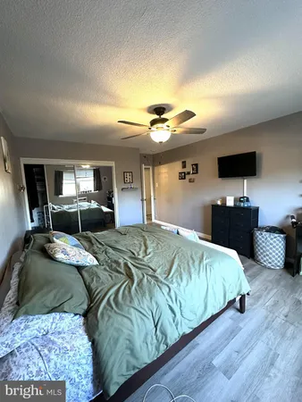 a bedroom with a large bed and a flat tv screen on dresser