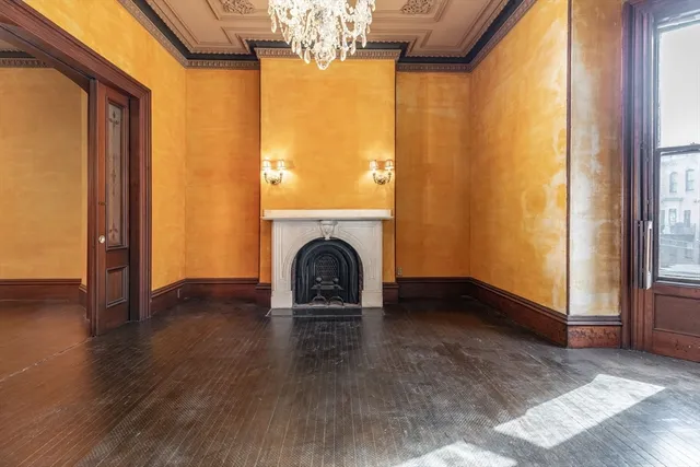 a view of empty room with fireplace and wooden floor