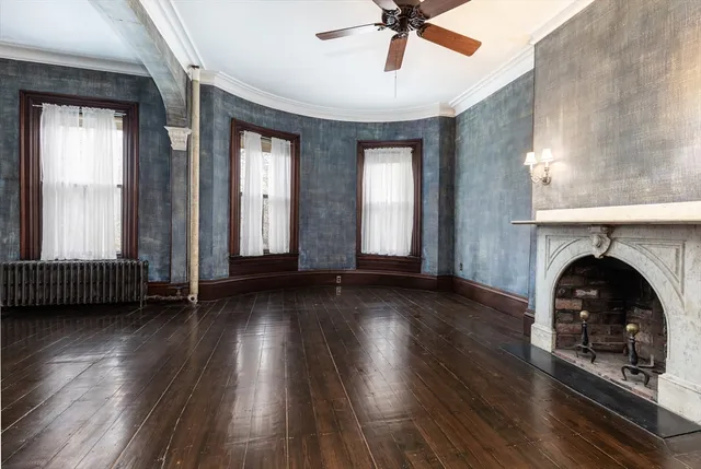 wooden floor fireplace and windows in an empty room