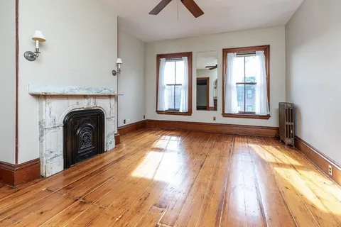 a view of a livingroom with wooden floor and a fireplace