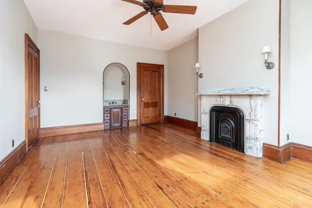 a view of empty room with wooden floor and fireplace