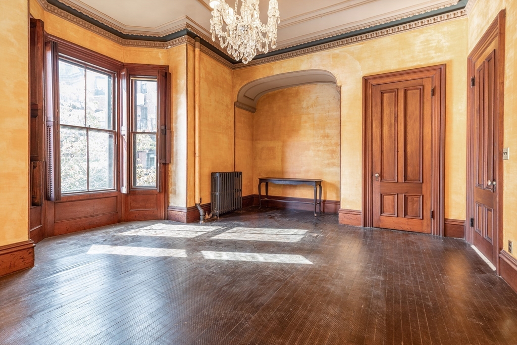 56 Rutland Square Boston, MA 02118 - Photo 10 of 29 a view of an empty room with a window and wooden floor