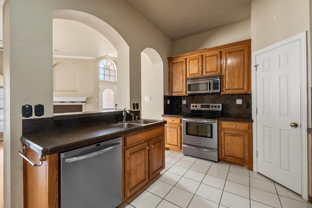 2327 Ragland Road Mansfield, TX 76063 - Photo 11 of 31 a kitchen with stainless steel appliances granite countertop a stove a sink and a microwave