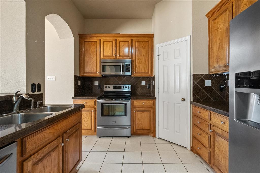 2327 Ragland Road Mansfield, TX 76063 - Photo 12 of 31 a kitchen with stainless steel appliances a stove sink and cabinets