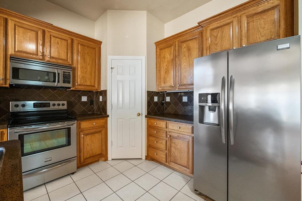 2327 Ragland Road Mansfield, TX 76063 - Photo 15 of 31 a kitchen with granite countertop a refrigerator and a stove top oven