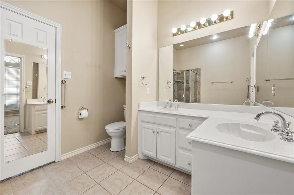 2327 Ragland Road Mansfield, TX 76063 - Photo 24 of 31 a bathroom with a toilet a sink and a mirror