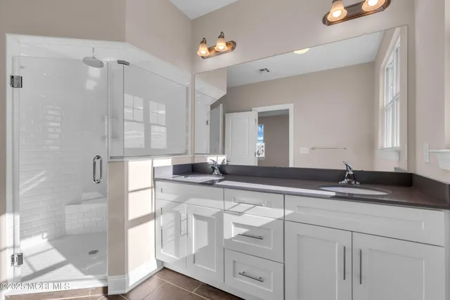 a bathroom with double sink and a mirror