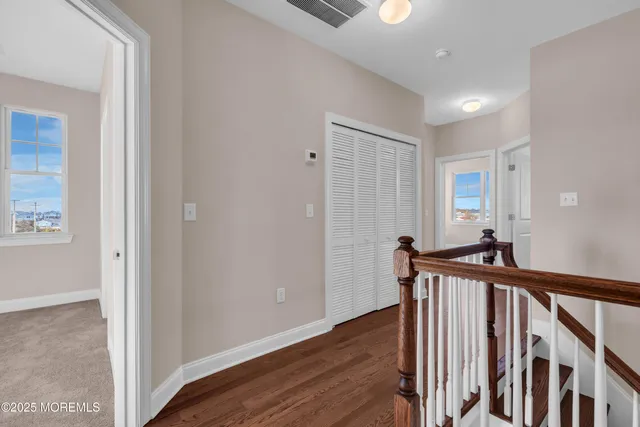a view of a hallway with a livingroom and stairs