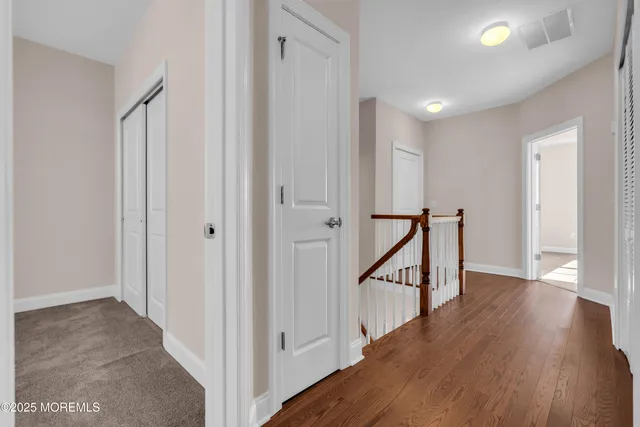 a view of a hallway with wooden floor and entryway