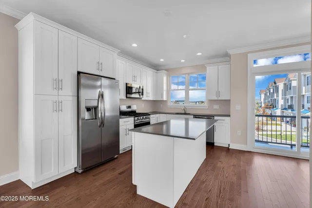 a kitchen with stainless steel appliances granite countertop a refrigerator and a stove top oven