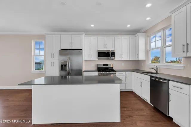 a kitchen with kitchen island a counter top space cabinets a sink and a stove