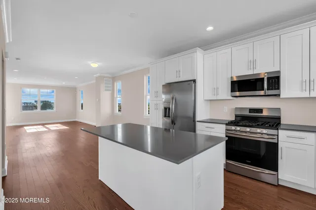 a kitchen with stainless steel appliances granite countertop a stove a refrigerator and a microwave