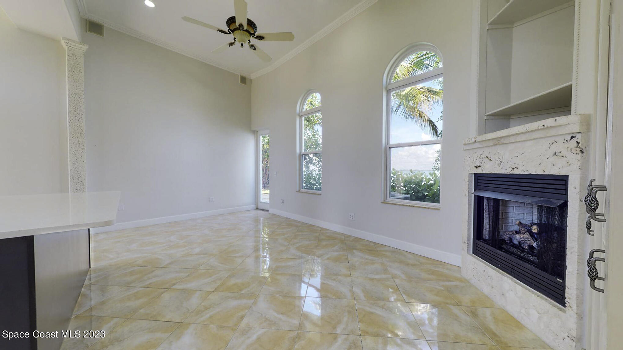 21 West Point Drive, Unit 101 Cocoa Beach, FL 32931 - Photo 24 of 59 a view of an empty room with a fireplace and a window