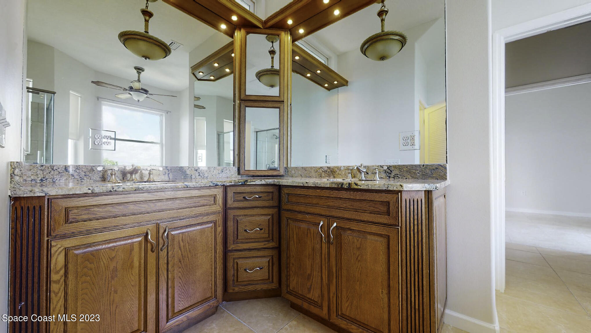 21 West Point Drive, Unit 101 Cocoa Beach, FL 32931 - Photo 35 of 59 a bathroom with a granite countertop sink a mirror and a vanity