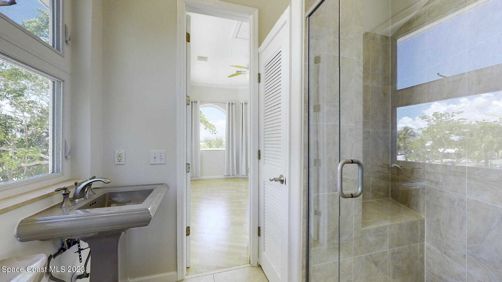21 West Point Drive, Unit 101 Cocoa Beach, FL 32931 - Photo 39 of 59 a bathroom with a sink a toilet and a shower