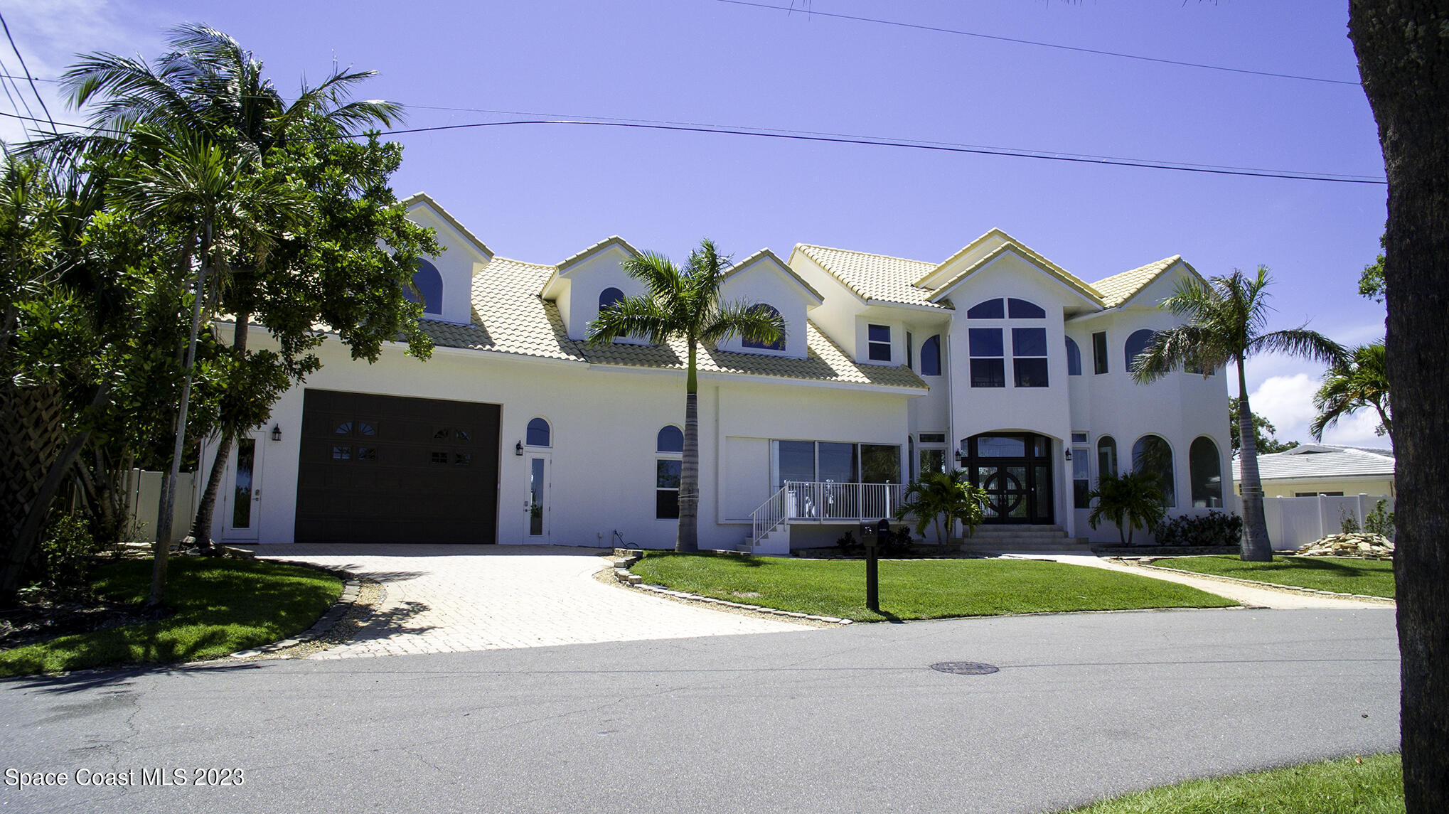 21 West Point Drive, Unit 101 Cocoa Beach, FL 32931 - Photo 4 of 59 a front view of a house with a yard and garage
