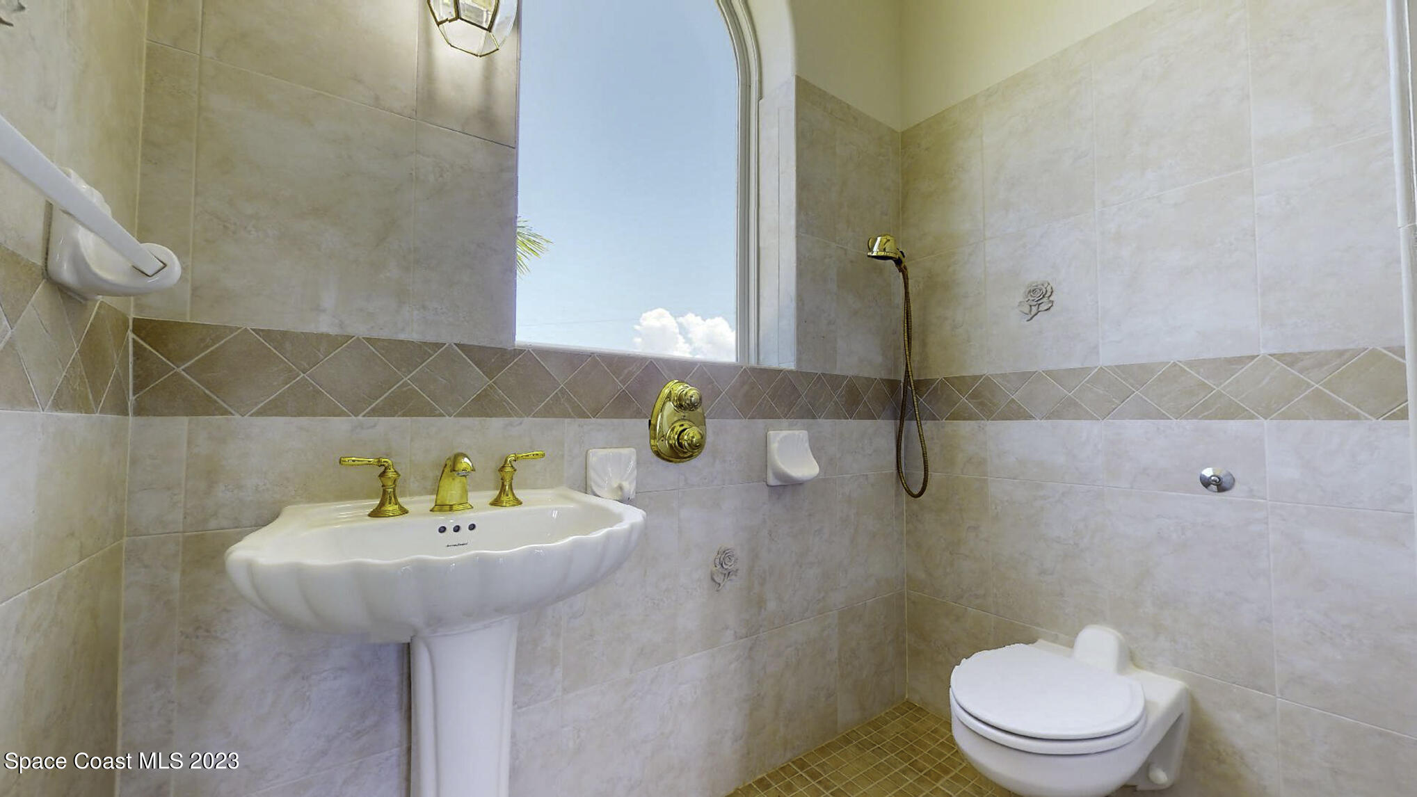 21 West Point Drive, Unit 101 Cocoa Beach, FL 32931 - Photo 46 of 59 a bathroom with a sink a toilet and a mirror