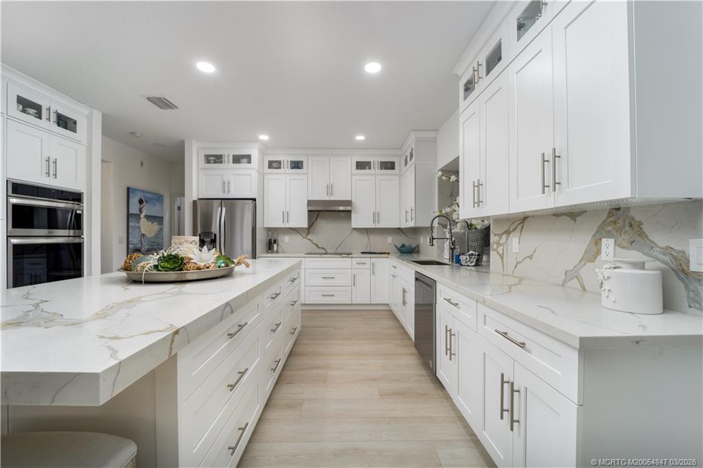 1257 Southeast Brewster Place Stuart, FL 34997 - Photo 15 of 35 a kitchen with kitchen island granite countertop lots of white stainless steel appliances cabinets and a sink