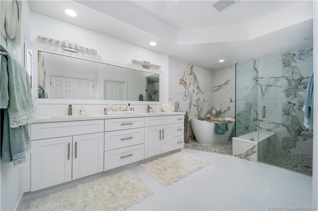 1257 Southeast Brewster Place Stuart, FL 34997 - Photo 23 of 35 a spacious bathroom with double vanity a toilet a sink and mirror