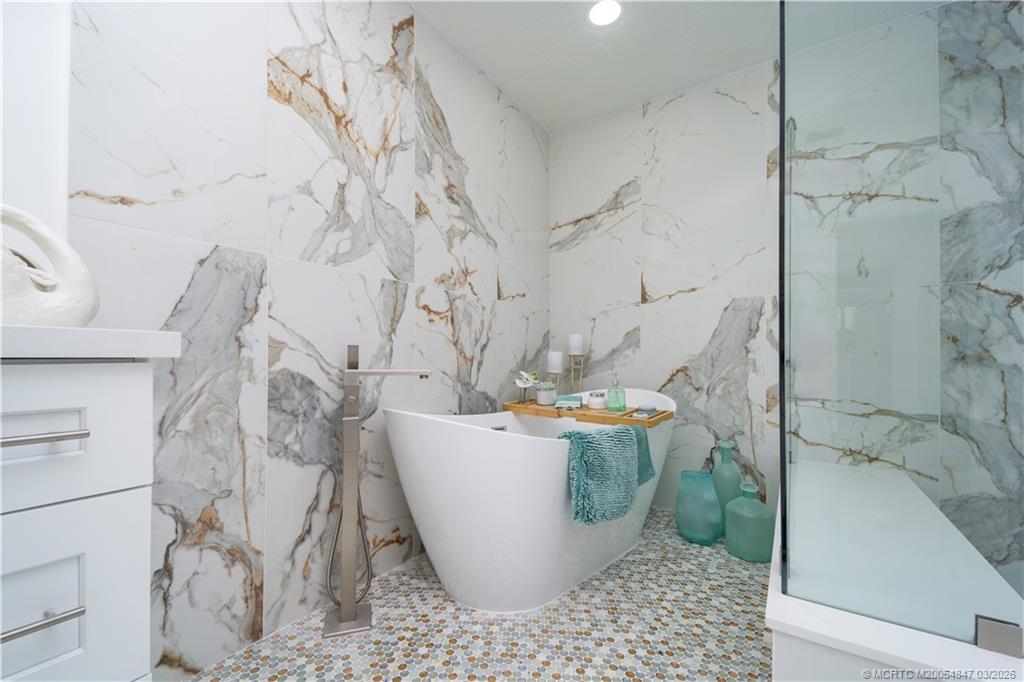 1257 Southeast Brewster Place Stuart, FL 34997 - Photo 25 of 35 a white bath tub sitting in a bathroom