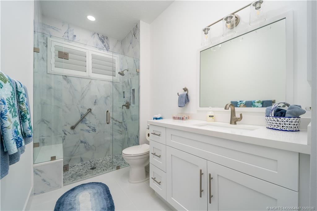1257 Southeast Brewster Place Stuart, FL 34997 - Photo 30 of 35 a bathroom with a sink a toilet and shower