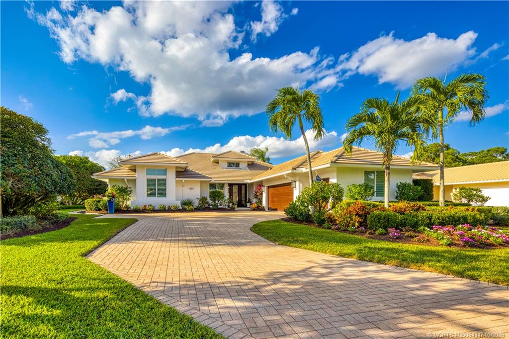 1257 Southeast Brewster Place Stuart, FL 34997 - Photo 5 of 35 a view of a white house with a yard and potted plants