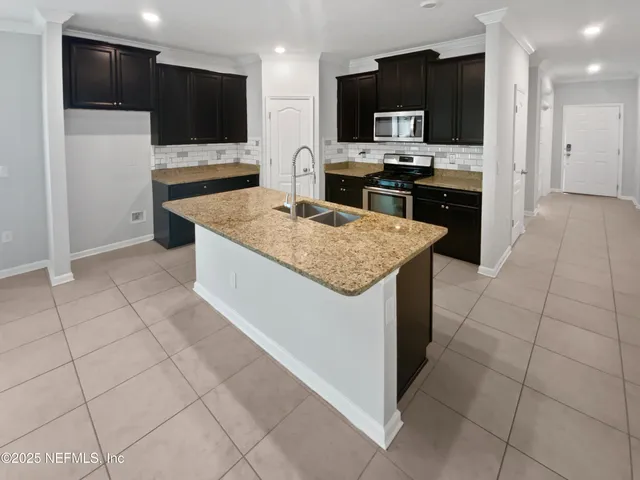 a kitchen with stainless steel appliances granite countertop a refrigerator and a stove top oven