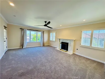a view of an empty room with a window and fireplace