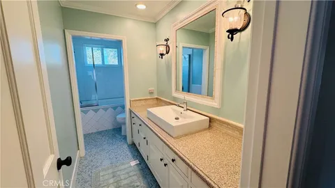 a bathroom with a granite countertop sink a mirror and a shower